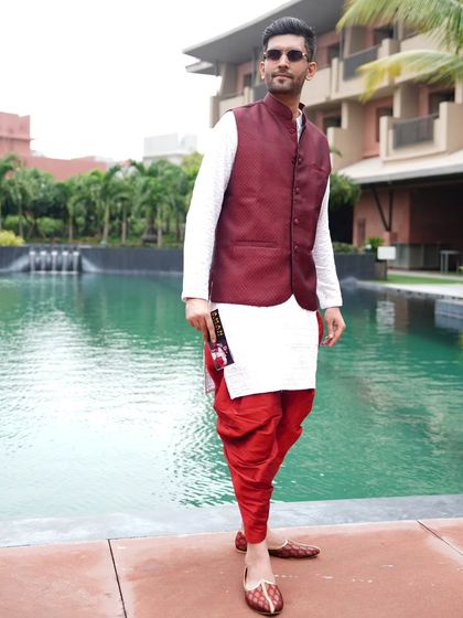 Posing by the pool in a traditional yet stylish outfit, perfect for a destination wedding function.