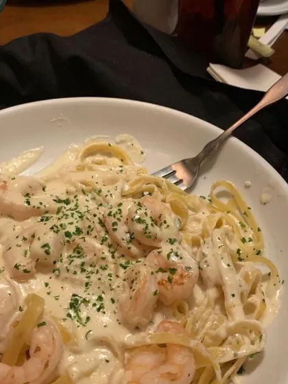 A close-up of a creamy shrimp Alfredo pasta, one of the continental dishes I offer for private dinner parties. The dish is garnished with fresh parsley, ready to be enjoyed.