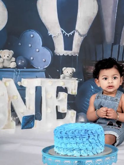 A cool blue theme for a little boy's first birthday cake smash. The hot air balloon backdrop and teddy bears create a dreamy and adventurous setting for his celebration.