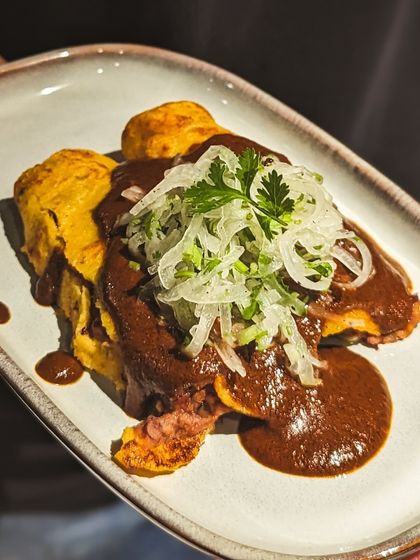 An omelette with a rich, dark mole sauce, created for our cacao and corn-themed dinner. This dish highlights the traditional Mesoamerican pairing, using chocolate in a savory application to create deep, complex flavors.