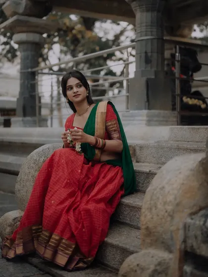 A traditional portrait taken at a temple, with the architecture providing a stunning backdrop. The model's pose and the soft lighting create a serene and classic image.