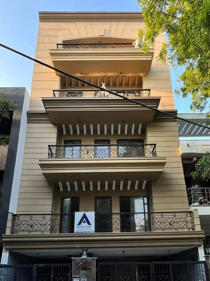 A street-level view of the C-257 building, showing its impressive presence. The combination of architectural details, greenery, and dedicated stilt parking makes it a highly desirable property.