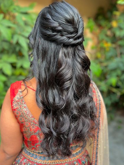 A beautiful half-updo with a twisted knot, showcasing soft waves and a classic silhouette.