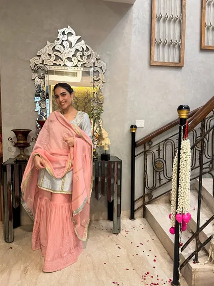 A full-length view of the sharara outfit against the backdrop of our home's staircase. The outfit is perfect for celebrating at home.