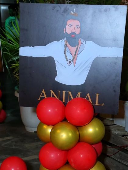 Custom posters are a fantastic way to personalize a theme. This 'Animal' movie poster parody was a fun and edgy addition to the Bollywood party decor.
