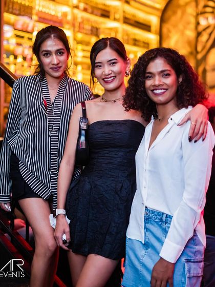 Three stylishly dressed friends posing for a photo.