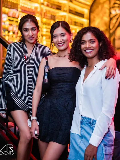 Three stylishly dressed friends posing for a photo.