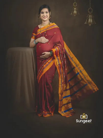 A full-length portrait showcasing a traditional Ilkal or Paithani saree, with hanging temple bells in the background to enhance the cultural theme.
