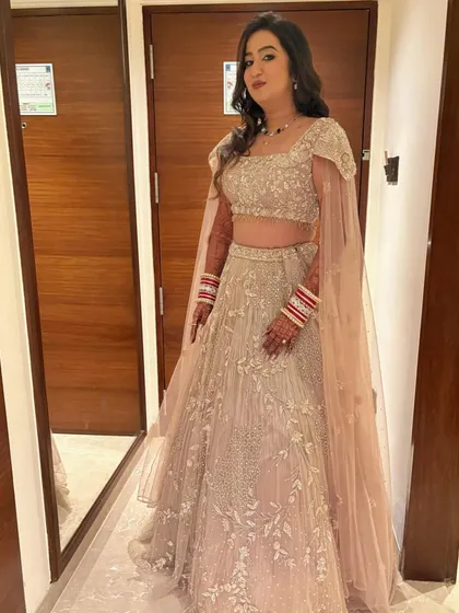 A full view of the elegant reception lehenga with cape sleeves, paired with soft glam makeup for a modern yet timeless feel.