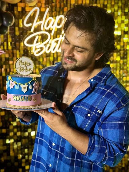 A special "Papa to be" cake for Shoaib Ibrahim's birthday, celebrating his journey into fatherhood. The cake is decorated with a clothesline of edible baby items.