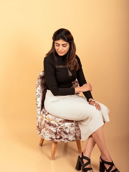 A sophisticated seated portrait in the studio. This shot combines professional style with a relaxed pose, perfect for a modern headshot.