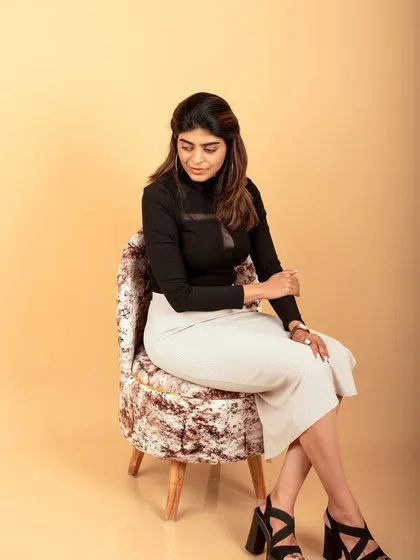 A sophisticated seated portrait in the studio. This shot combines professional style with a relaxed pose, perfect for a modern headshot.