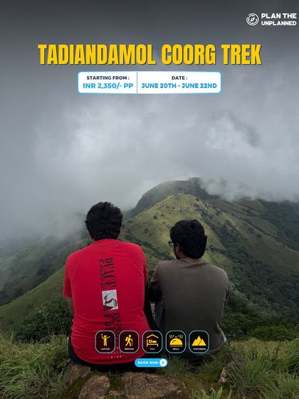 Two friends sit and enjoy the misty mountain view on the Tadiandamol Coorg trek.