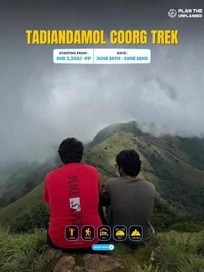 Two friends sit and enjoy the misty mountain view on the Tadiandamol Coorg trek.