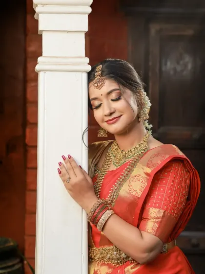 A behind-the-scenes and final look from a makeup artist's portfolio shoot. The model is in a classic red bridal saree, showcasing the transformation and the beautiful final result.