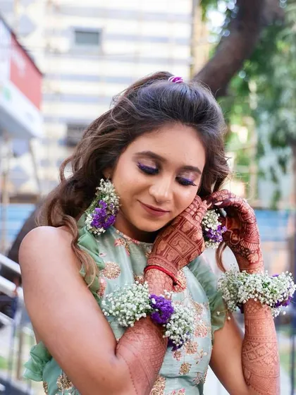 A close-up of the bride's unique Haldi look. The pop of purple on her eyelids is a fun and modern twist on traditional Haldi makeup.