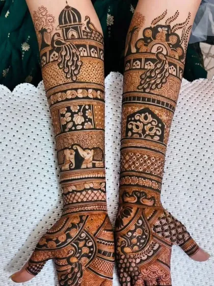 This full bridal design includes bands of marching elephants and peacocks, adding a sense of procession and grandeur to the overall look.