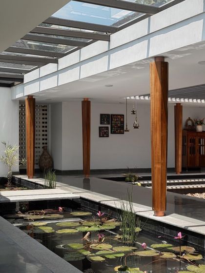 The central water court of the 'House of Quad' is a stunning feature, reflecting the sky and bringing a sense of coolness and tranquility to the interior.