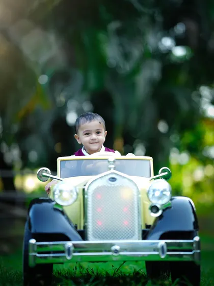 A little driver enjoys the open air in his vintage toy car. Our outdoor sessions allow for fun action shots like this.