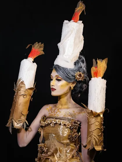 A profile view that showcases the sculpted details on the costume and the careful blending of gold body paint on the skin.
