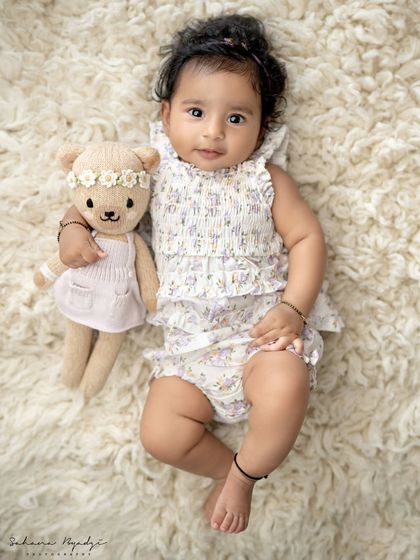 The cuteness of 100 days. This little one, at her 3-month milestone, is looking adorable with her teddy bear friend.