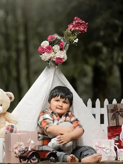 A cozy moment with a favorite stuffed animal. This three-year-old boy is enjoying a quiet moment in his teepee during his birthday photoshoot.