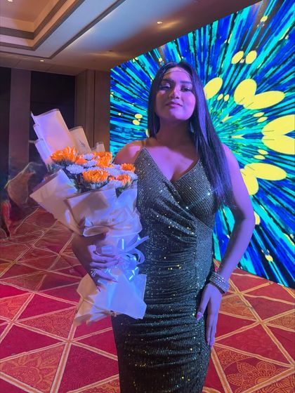 Holding a bouquet in a shimmery olive green gown. This look is perfect for a cocktail party or an evening reception with its subtle sparkle.