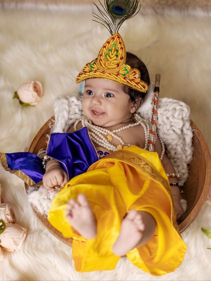 Another angle of our newborn Krishna in a basket, showing his tiny feet and the flowing yellow and blue costume. These detail shots are just as important as the portraits.