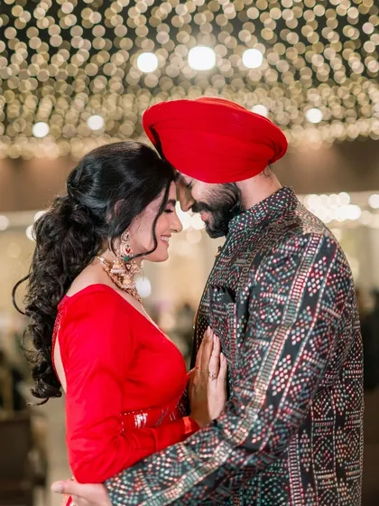 An intimate portrait of Vanaja and Angad under a ceiling of fairy lights. The warmth of the lights and their close embrace create a deeply romantic photograph.