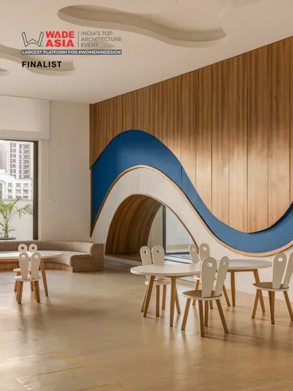 A classroom at Vedanya School featuring a playful, wave-like wall with a built-in tunnel. This imaginative design element turns the room into a landscape for discovery and creative play.