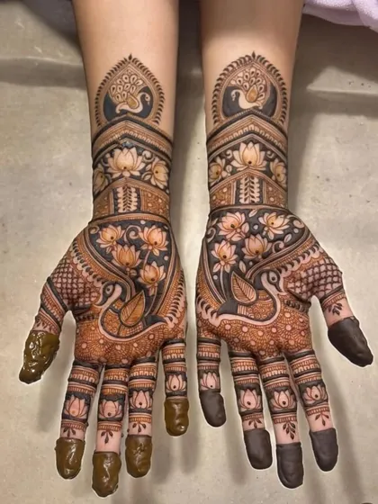 This design is a celebration of traditional Indian motifs. It features elegant peacocks on the wrists and palms, surrounded by a garden of lotus flowers, all done in my signature style with a guaranteed dark stain.