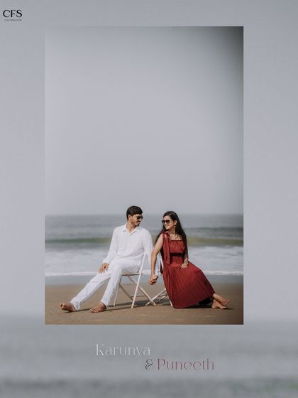 A minimalist and elegant beach portrait. The simple composition with the couple seated by the ocean creates a calm and timeless feel.