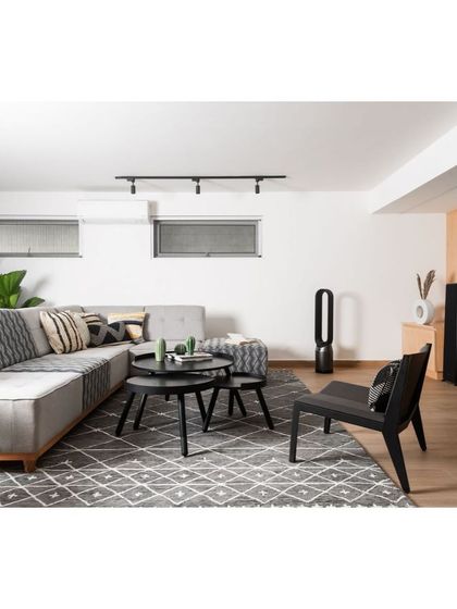 An identical view of the living room, showcasing the clean lines of the furniture and the geometric-patterned rug that adds texture and visual interest.
