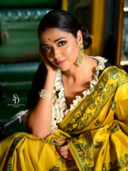 A beautiful close-up of Sohini Sarkar, her face framed by her hand. Her gentle expression and the rich colors of her outfit make for a captivating portrait.