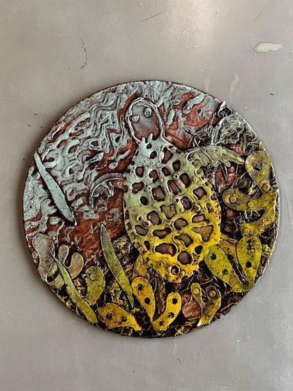 A sea turtle glides through a textured seascape in this lovely collagraph print. The student did a fantastic job of building layers on the plate to create a sense of depth and movement in the final artwork.