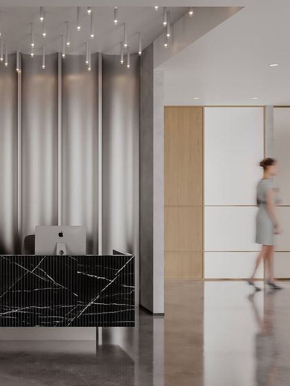 This view shows the dynamic relationship between the reception and the hallway. The fluted metallic wall behind the desk adds a touch of glamour, while the polished concrete floor reflects light and adds to the modern, clean aesthetic.