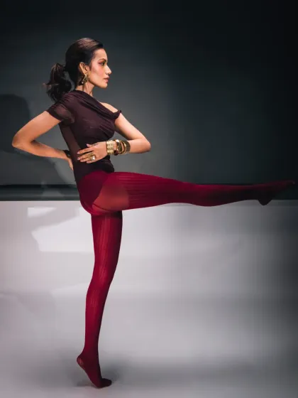 A creative pose that showcases the model's flexibility and the unique styling of the outfit. This kind of conceptual shot is perfect for an artistic editorial spread.