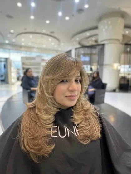 Blonde and beautiful. This look features face-framing layers and a bright blonde color, all styled into a voluminous, layered cut.