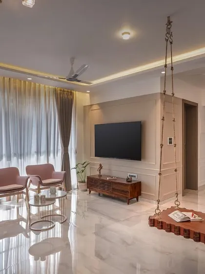 This living room captures the soft, chic, and lively look that pastel shades can bring to a space. We combined an olive green sofa with dusty pink armchairs and a rustic wooden swing to create an inviting atmosphere. The result is a home that feels both stylish and comfortable, reflecting the owner's personality.