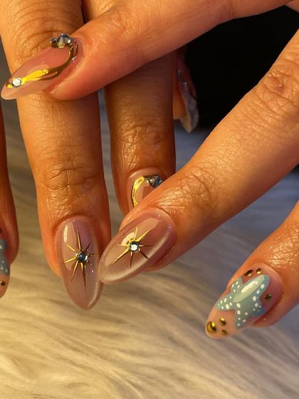 Another look at our celestial-themed nail art. This angle highlights the sparkling starbursts and the combination of different patterns and textures in one cohesive set.