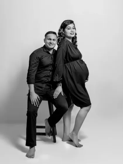 A modern and stylish couple's portrait in black and white. The mix of sitting and standing poses adds a dynamic feel to this classic studio shot.