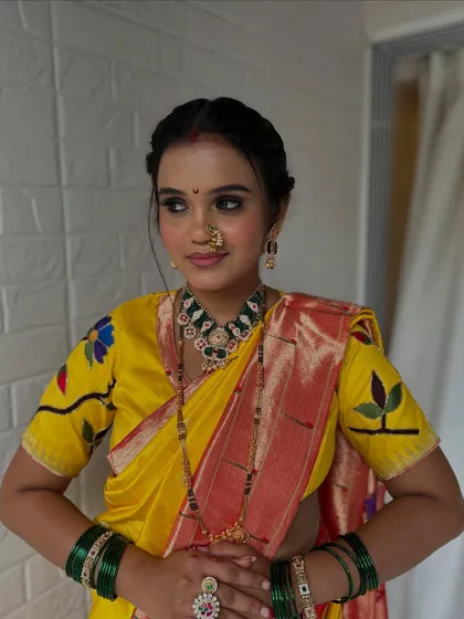 The complete look, showcasing the beautiful yellow and red saree, traditional jewelry, and the elegant braided updo. She looks every bit the perfect Maharashtrian bride.