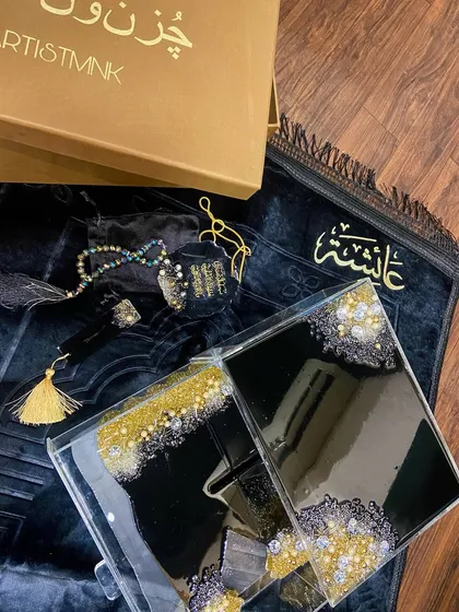 This luxurious black, gold, and silver combo set is a popular choice for a bridal gift. It includes a premium velvet prayer mat, a personalized acrylic Quran box, a resin Quran stand (rehal), a crystal tasbeeh, and a matching car hanging.