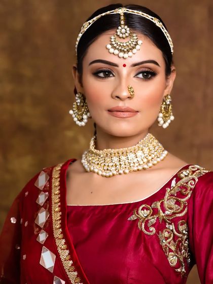 We believe in enhancing your natural beauty. This traditional bridal look features classic makeup and a matha patti, designed to make the bride feel like royalty.