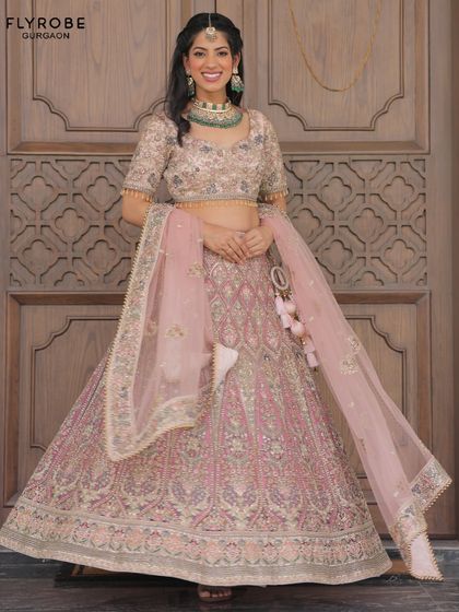 A full-length view of the beautiful pastel pink lehenga. The intricate embroidery and flattering silhouette make it a perfect choice for an engagement, sangeet, or even a modern bride.