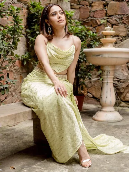 This lime green draped outfit by Punit Balanani on Nushrratt Bharuccha is perfect for a destination wedding. The cowl top and draped skirt create a chic, resort-style ethnic look.