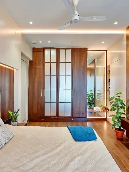 A closer look at the bedroom with chevron-patterned wood paneling. This angle shows the seamless integration of the frosted glass wardrobe doors, which add a touch of softness to the design.