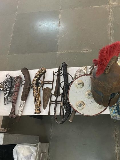 A collection of prop weapons like axes, swords, and a Roman helmet for the 'Pop Up Studio'.