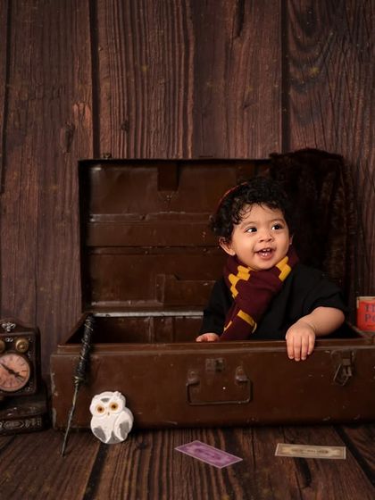 A magical smile from our little wizard. The warm, rustic wooden backdrop and Harry Potter books complete this enchanting first birthday theme.
