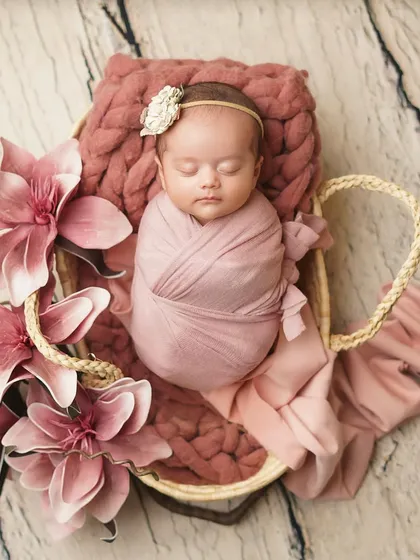 An overhead view of the floral basket setup, showcasing the beautiful composition of the baby, flowers, and textures. This is a great example of a styled newborn session.